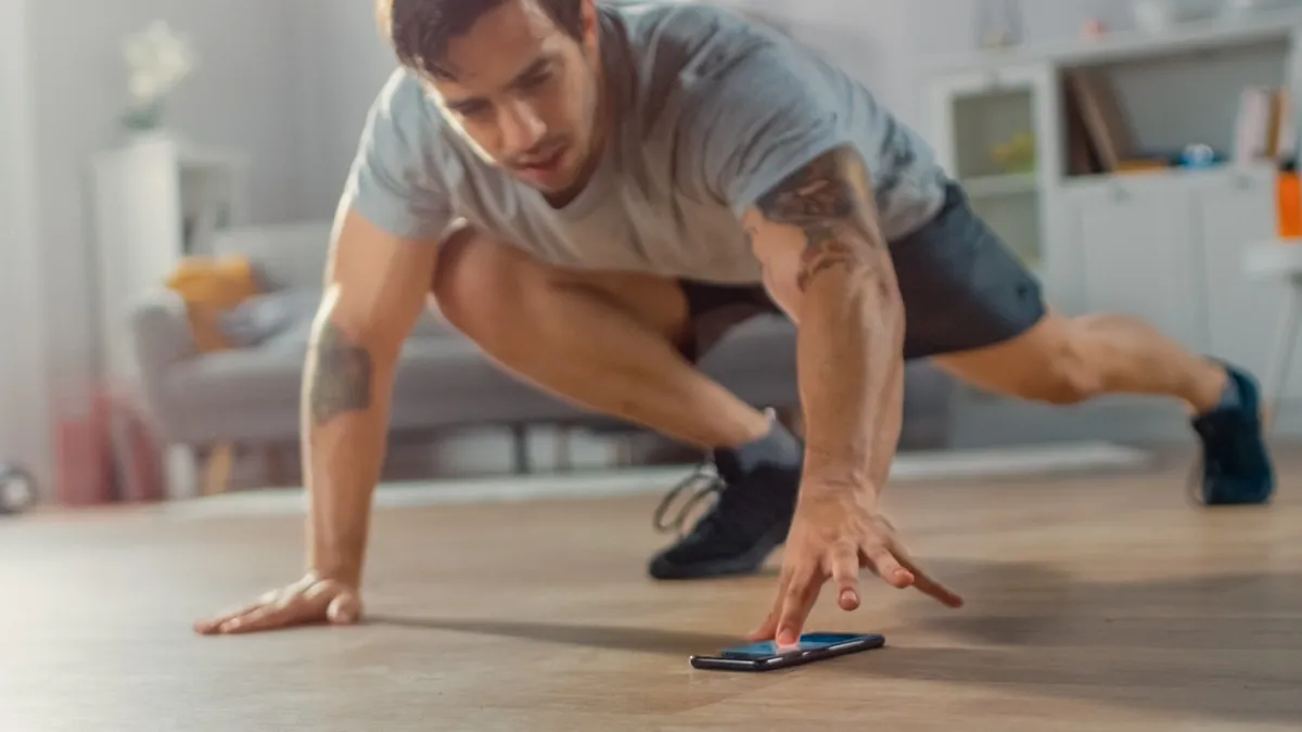 Man working out and doing mountain climbers in his living room