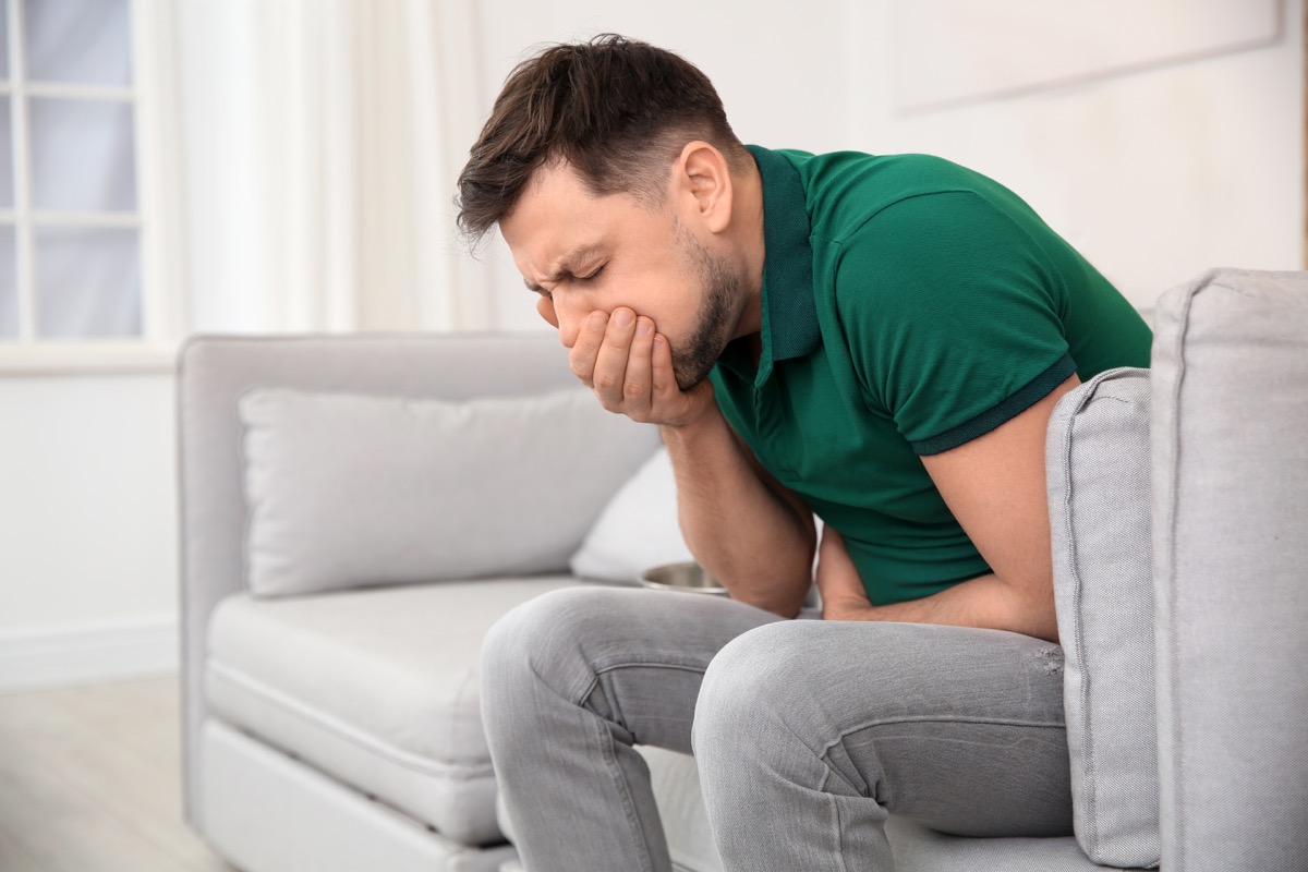 Nauseous man is bent over in pain with some sort of stomach bug
