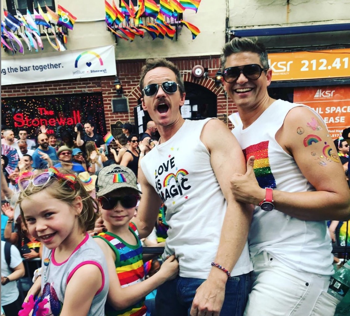 neil patrick harris, david burtka, and their two children in front of the stonewall inn at nyc pride