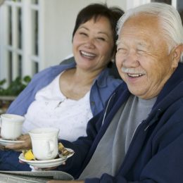 older asian couple drinking tea outdoors