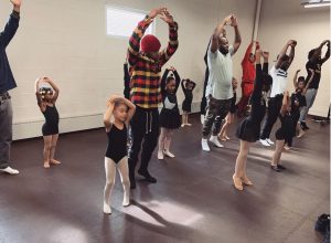 group of black fathers dancing with their daughters at ballet studio