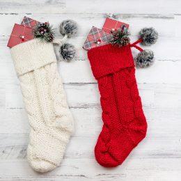 red and white cable knit christmas stockings on white background