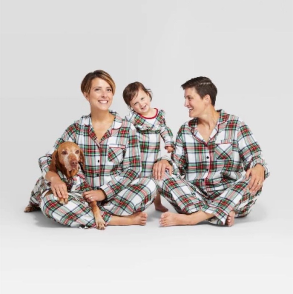 two mothers with daughter and dog in plaid pajamas