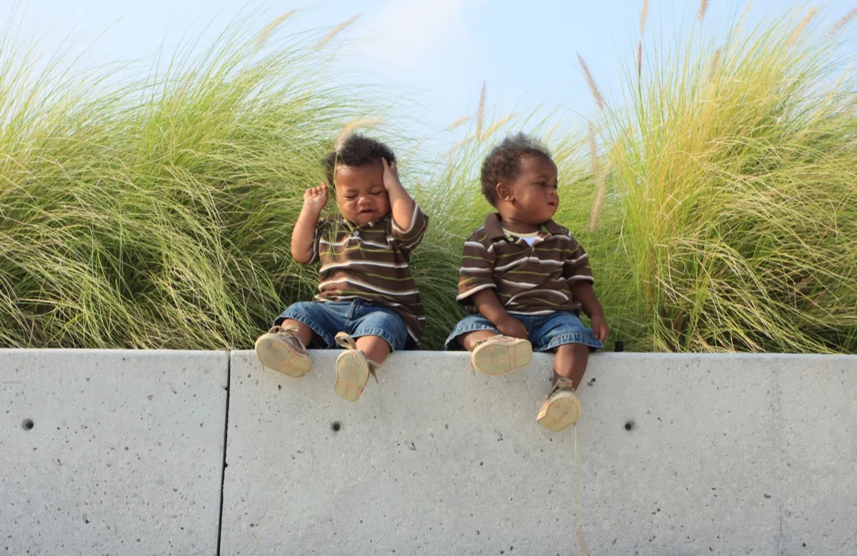 twin babies sitting on a ledge