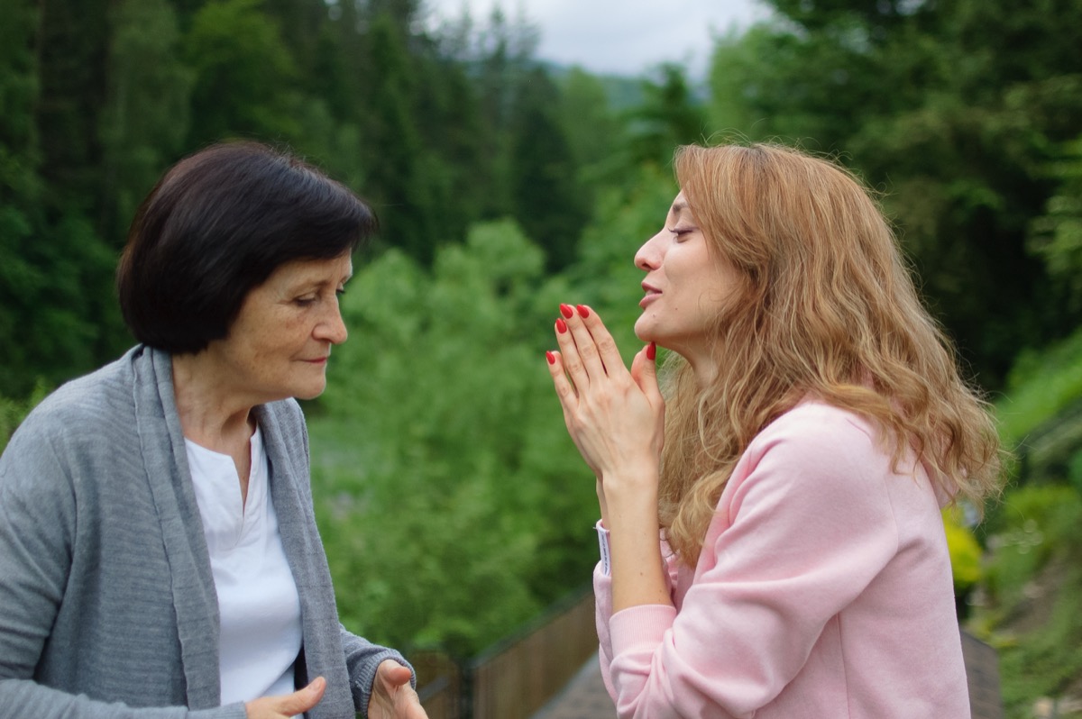 woman apologizing profusely to her mother outside