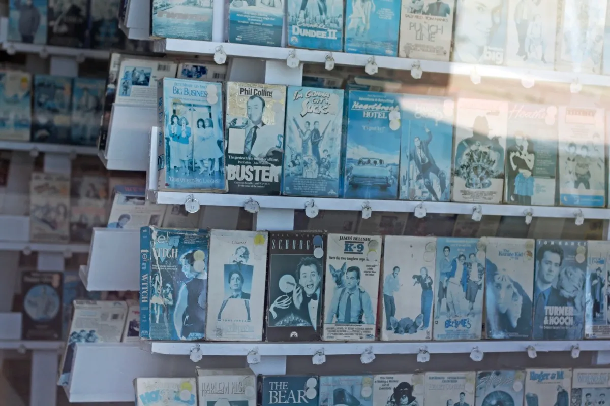 Salida, California, United States - April 22, 2010: Racks of long-forgotten and weather beaten, sun-bleached VHS tapes as seen through the window of an abandoned video rental store.