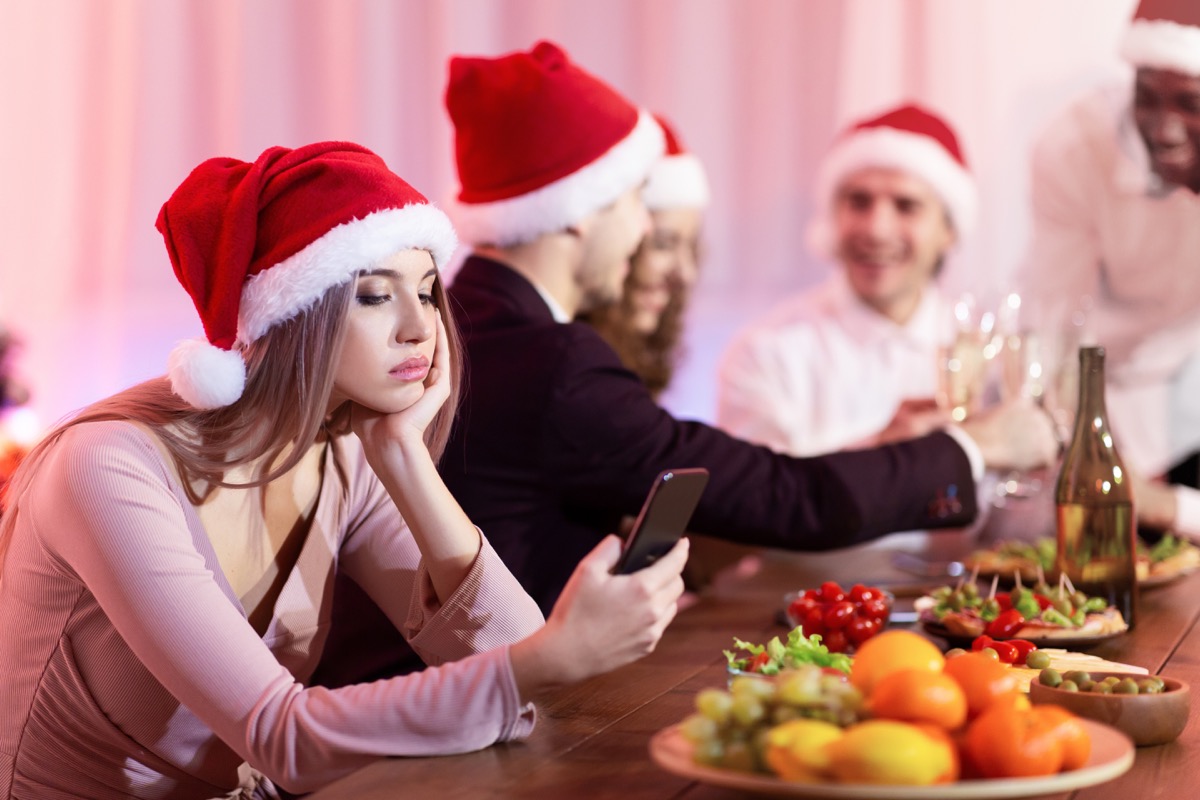 Woman looking bored and anxious at a Christmas party