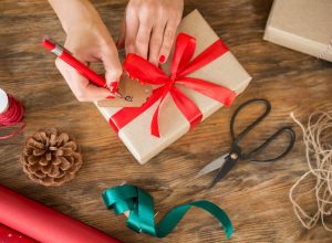 white woman filling out gift tag on christmas present