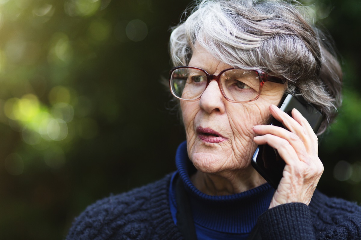 older woman looking anxious as she talks on the phone