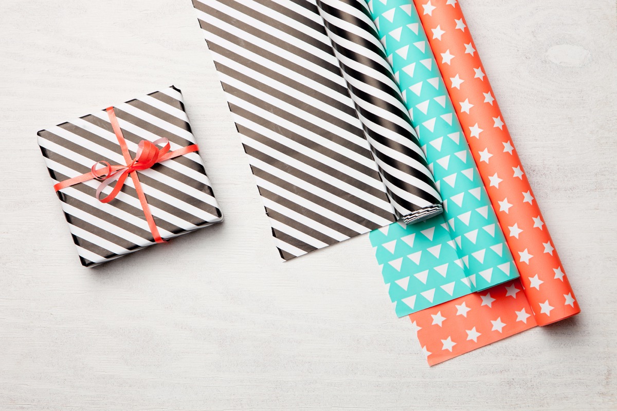 wrapping paper and gift on wooden background