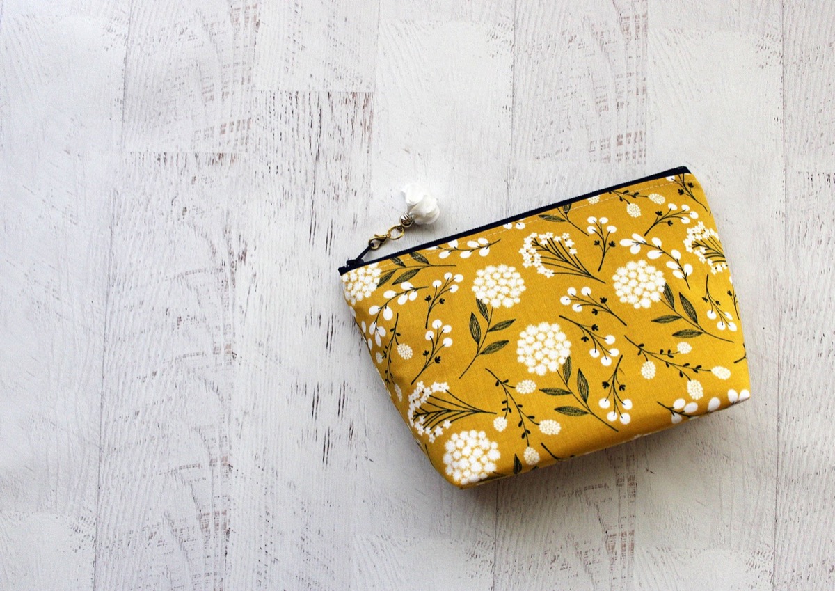 Yellow and white floral bag on wooden floor