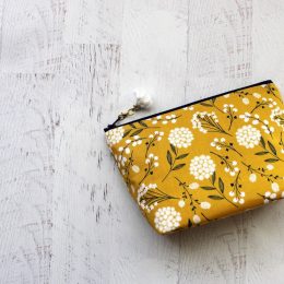 Yellow and white floral bag on wooden floor
