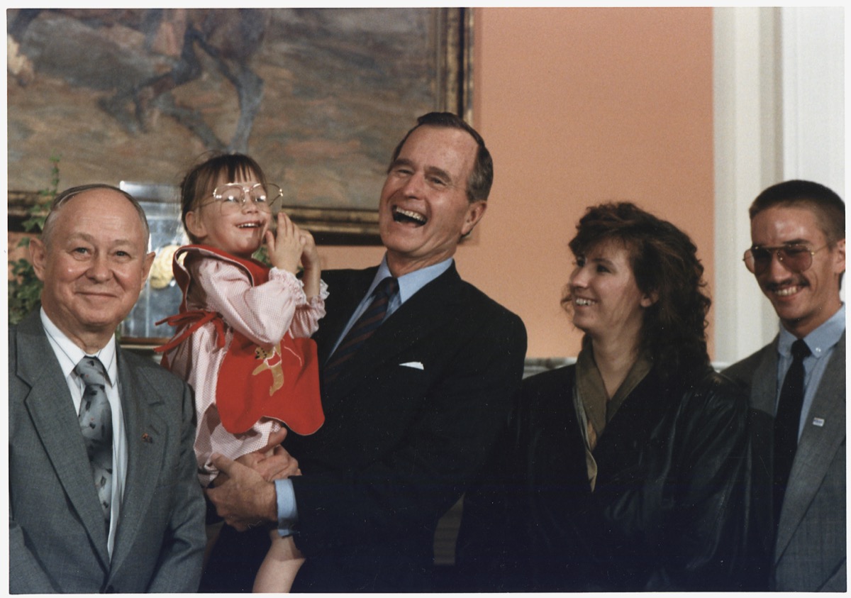 president george hw bush holding baby jessica alongside her family at the white house
