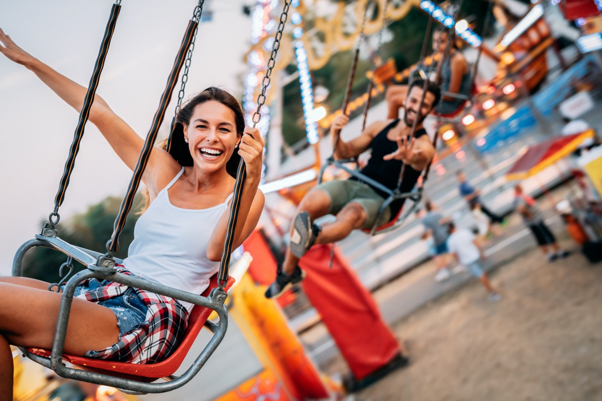 a girl on the swings at an amusement park
