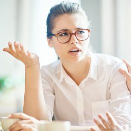 anxious woman explaining reason of her worry to friend by cup of coffee