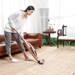 asian woman vacuuming area rug