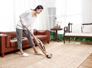 asian woman vacuuming area rug