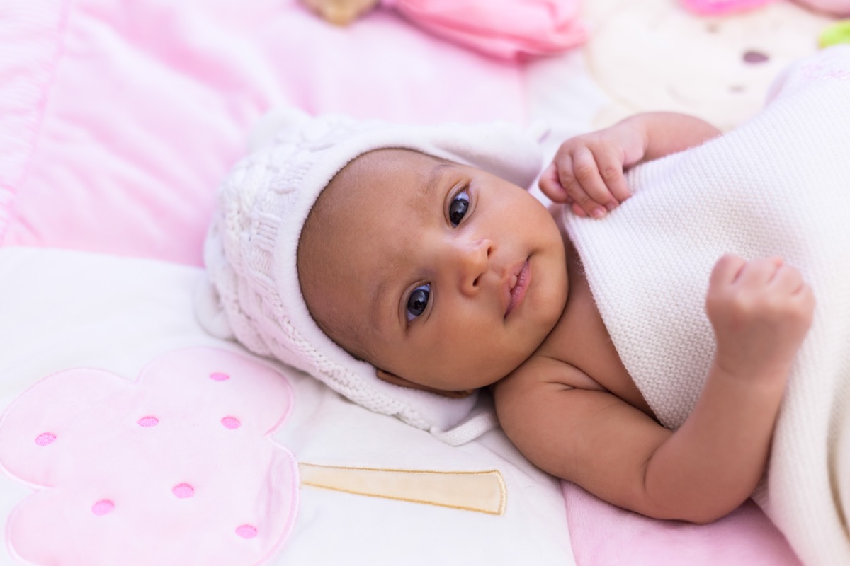 little baby girl on pink bedding