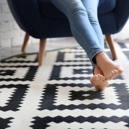 Person resting on black and white patterned rug