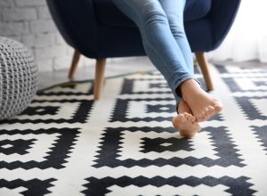 Person resting on black and white patterned rug