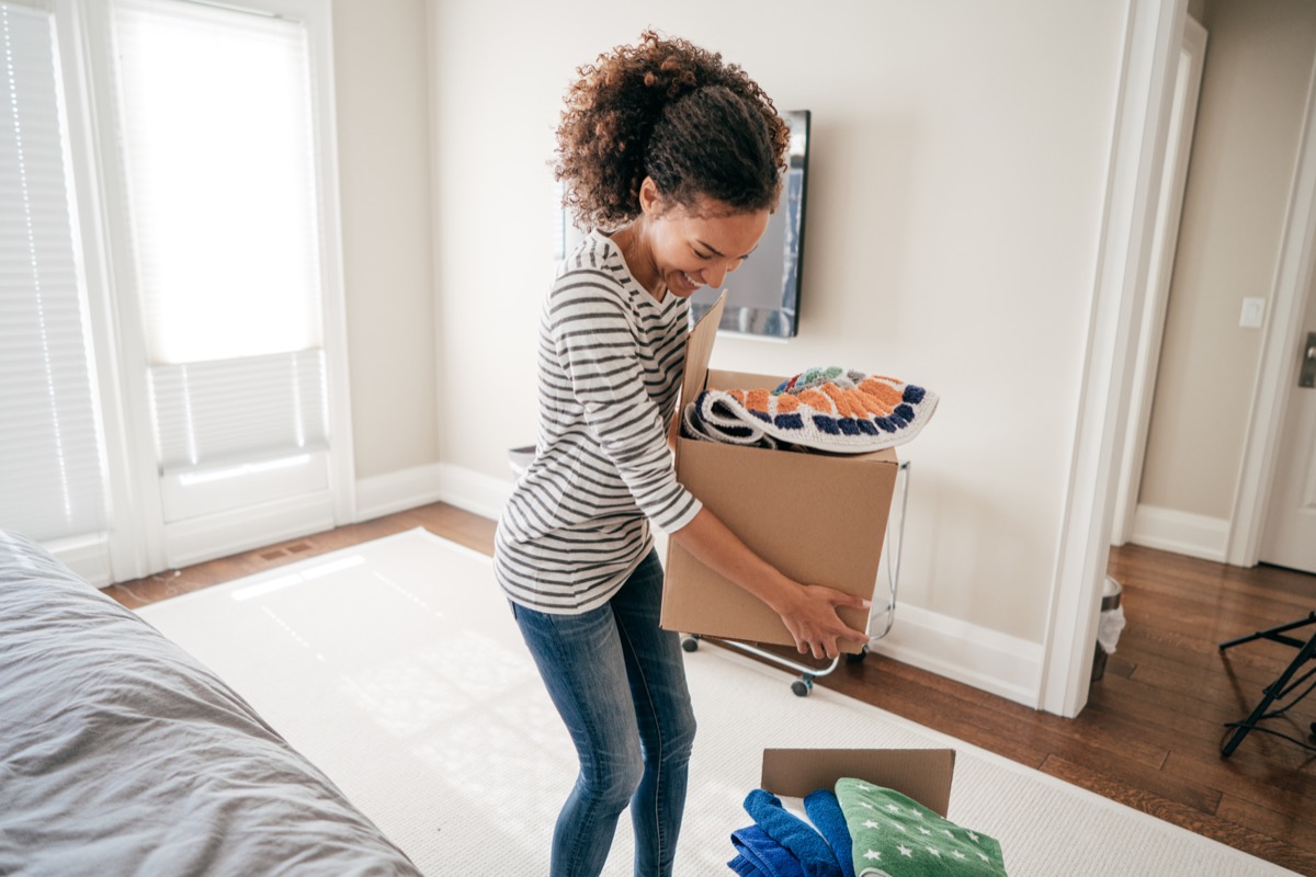 young black woman packing up boxes inside home