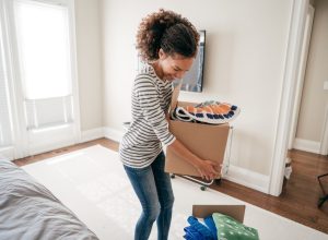 young black woman packing up boxes inside home