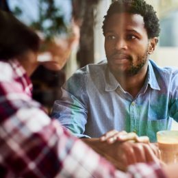 shot of an affectionate young couple having a discussion about something on their date at a coffee shop