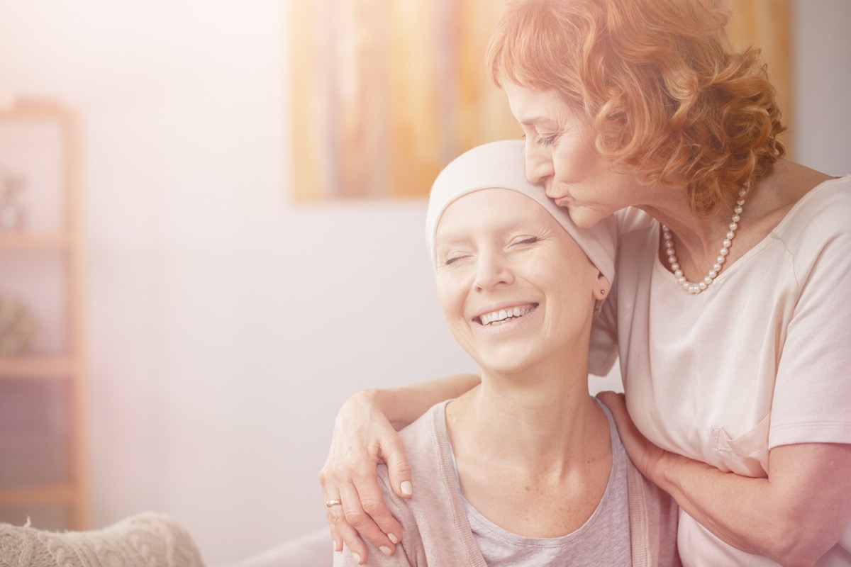Friend comforting woman with cancer
