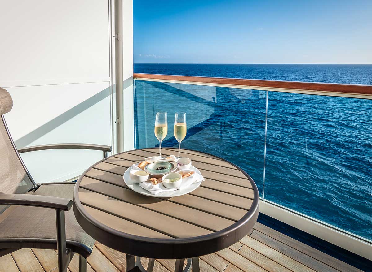 two glasses of champagne sit on a table on a cruise ship balcony