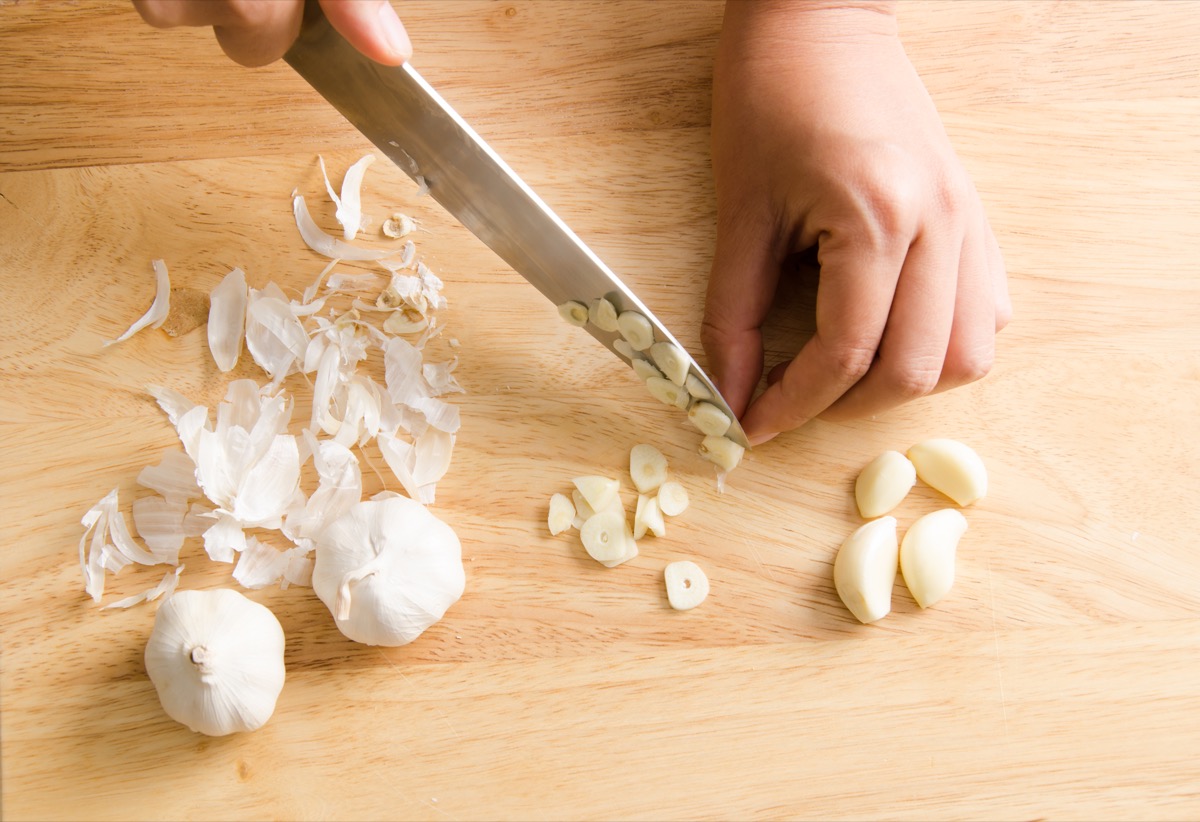 Person chopping garlic on a cutting board