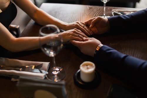 Couple holding hands at dinner