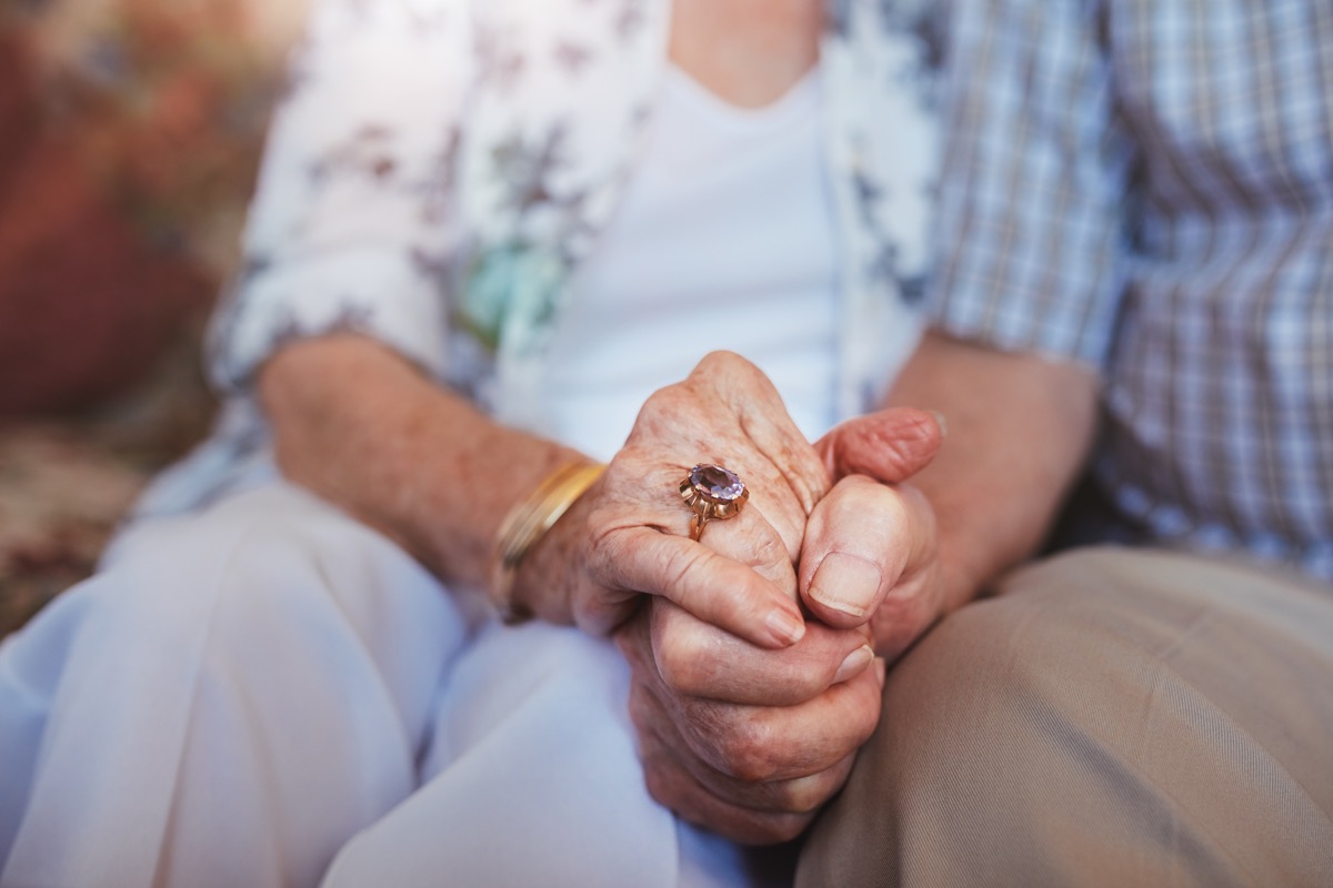 cropped shot of elderly couple holding hands