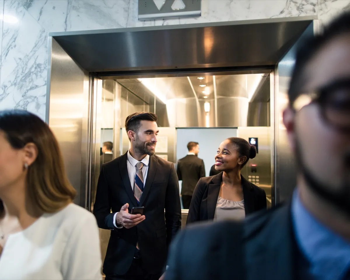 A multi-ethnic team of business executives walking out of an elevator in a business center