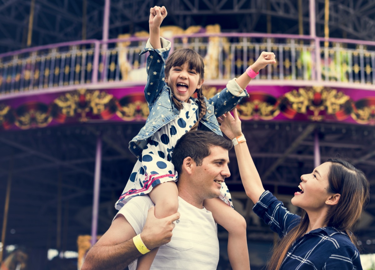 a family with a young daughter at an amusement park