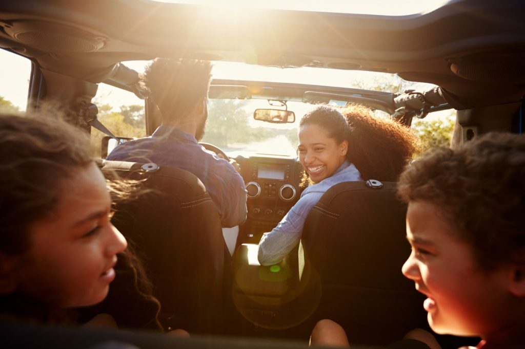 Une famille en road trip dans sa voiture baignée de soleil