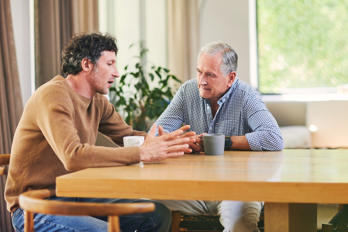 Shot of a mature man and his elderly father having coffee and a chat at home