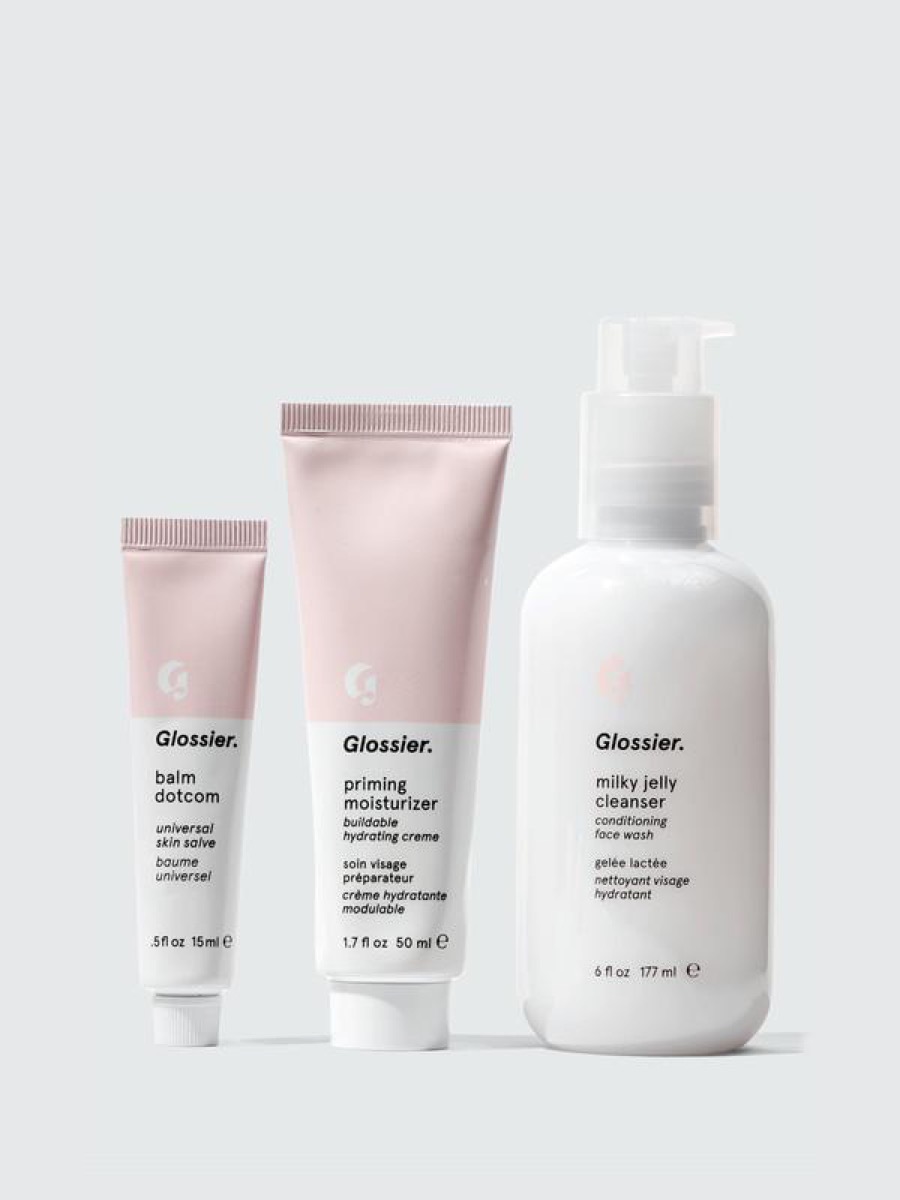 Glossier skincare products, gray background