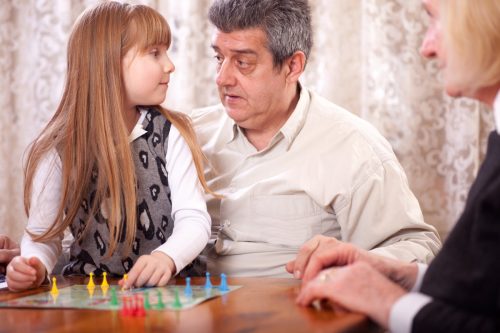 grandparents playing board game with granddaughter