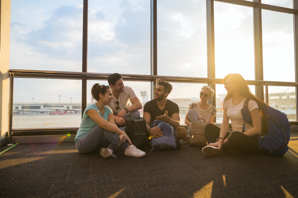 group of young adults sitting in airport