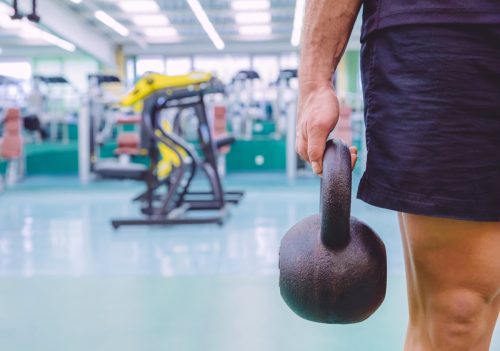 Man holding kettlebells at the gym