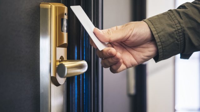 man scanning his key card on his hotel room door