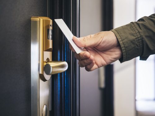 A man checks his key card on his hotel room door