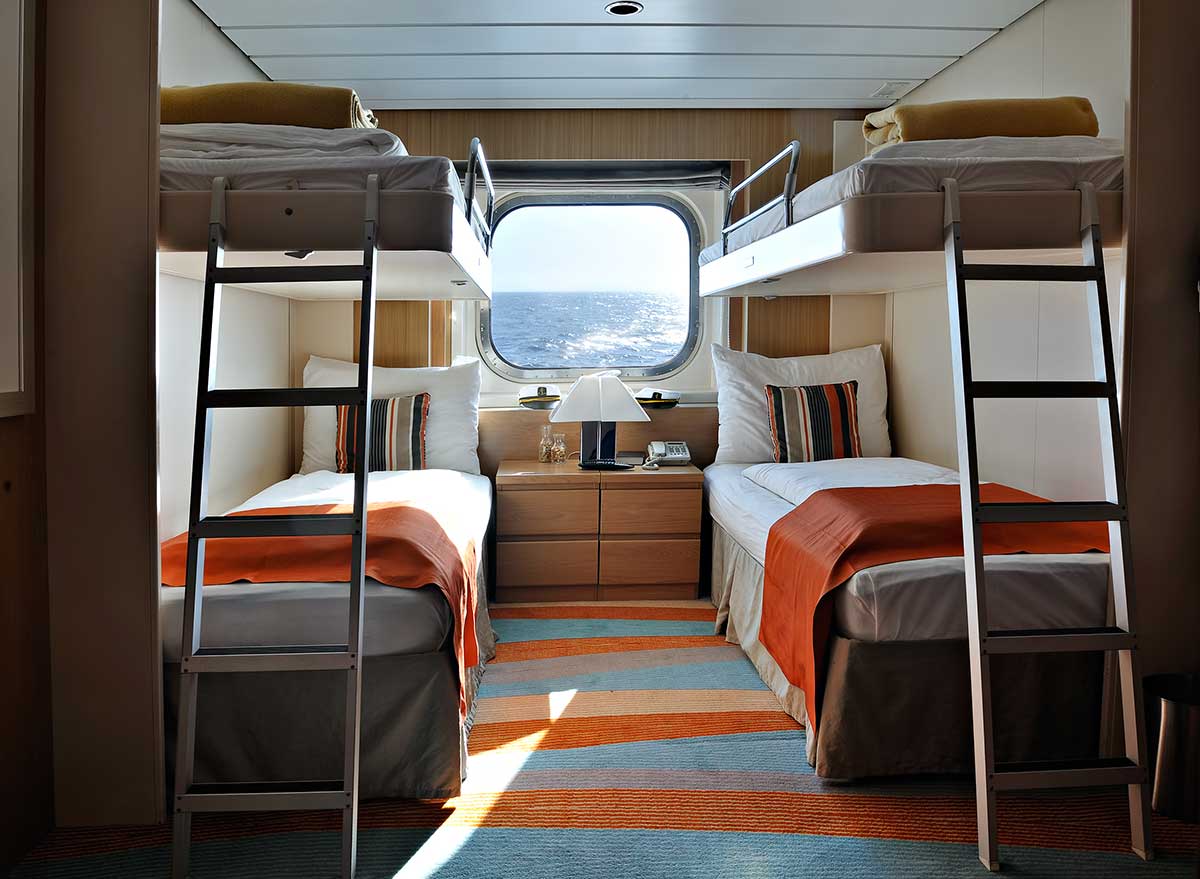 a cruise ship stateroom with two sets of bunk beds