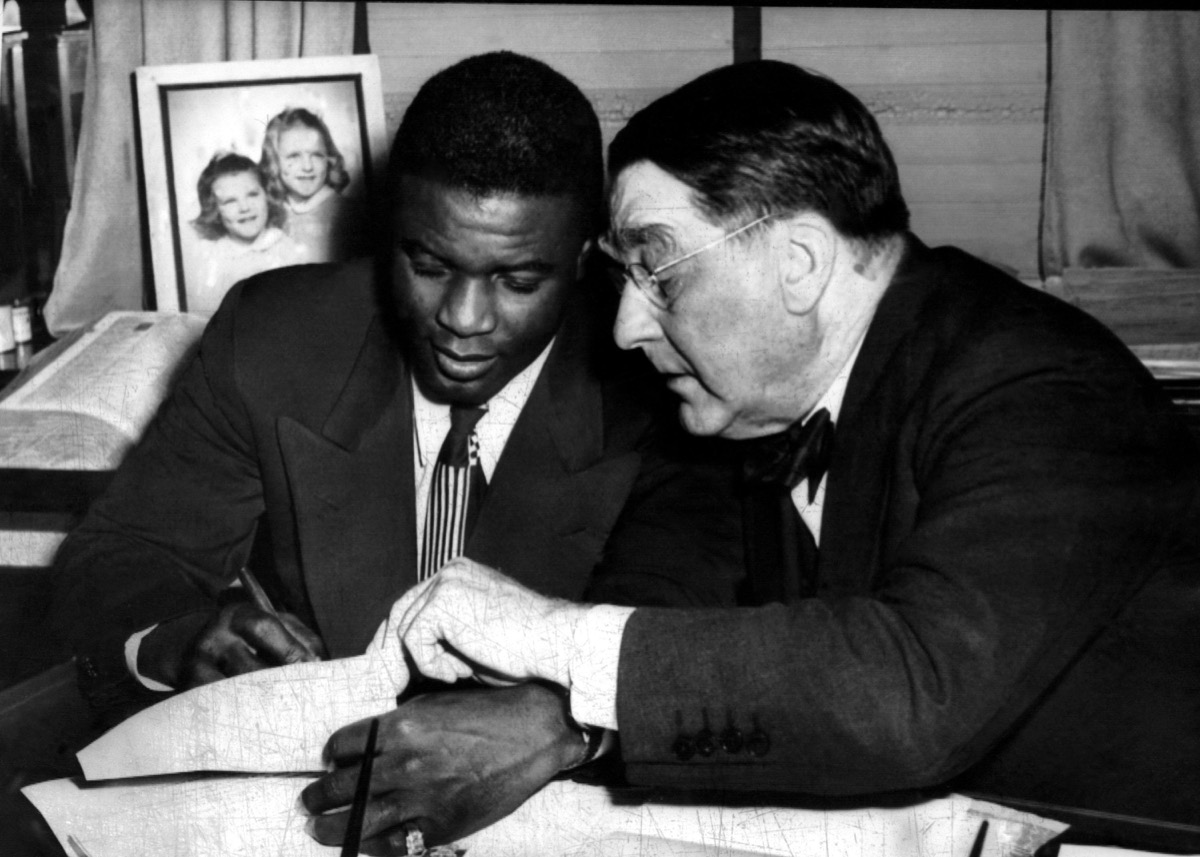 jackie robinson (left), being signed by branch rickey (right), to a one year contract to play for the Brooklyn Dodgers, 1945.