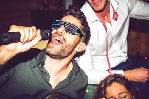 Man singing karaoke with friends