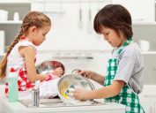 Kids sad while doing chores washing dishes together