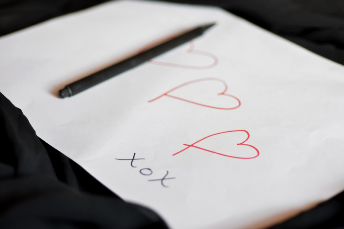 Любовная записка, написанная от руки в форме сердца на белой бумаге карандашом