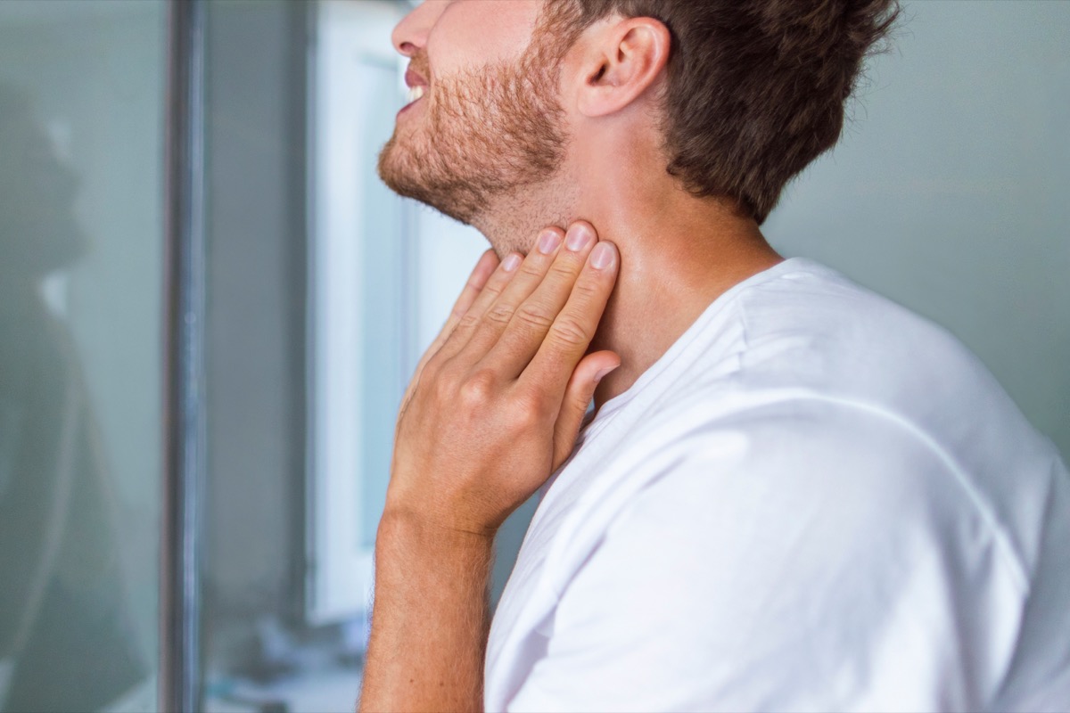 Man checking swollen thyroid