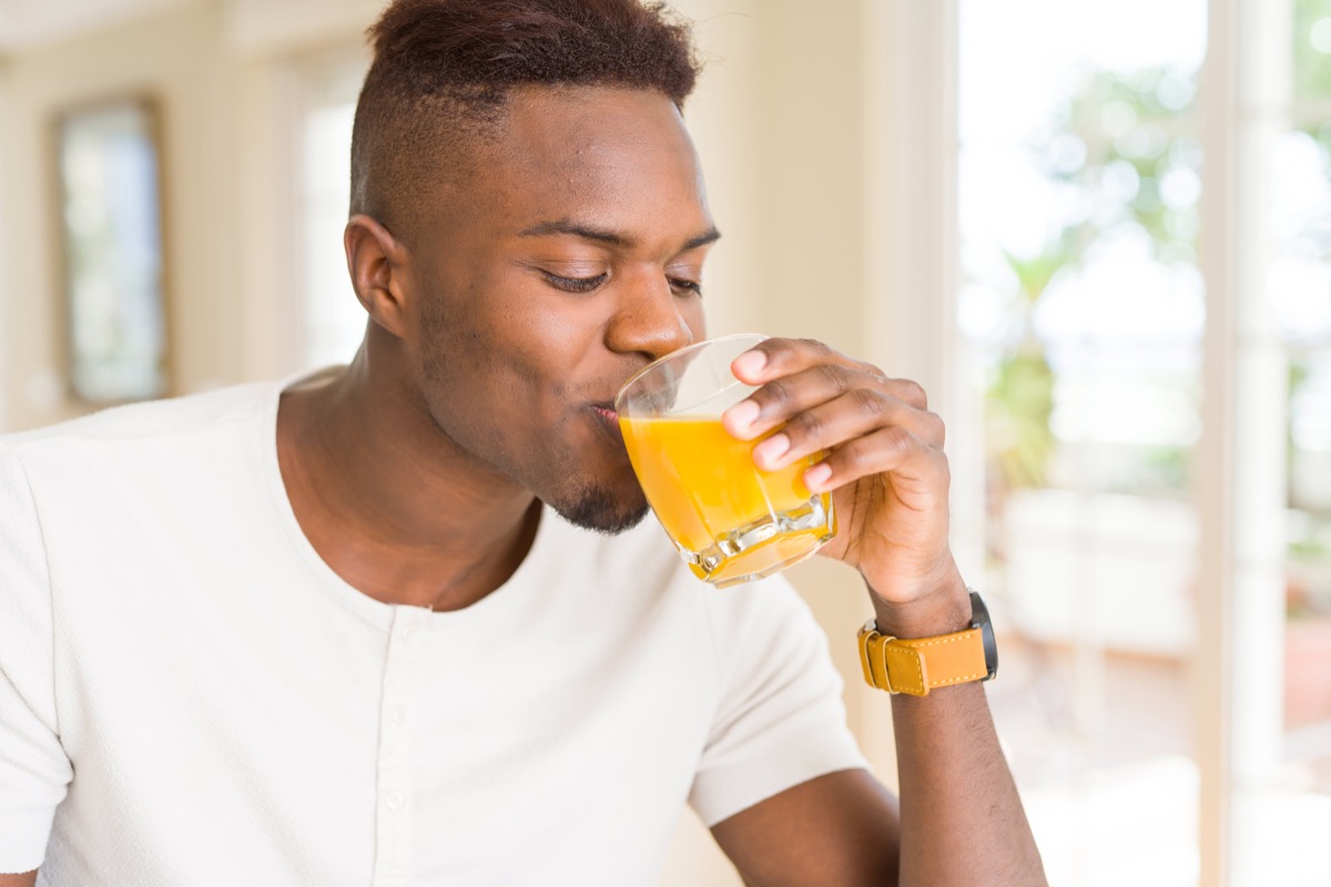Man drinking a glass of orange juice