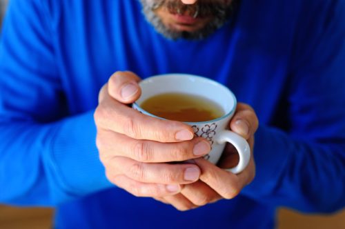 Bearded man drinking green tea from a mug